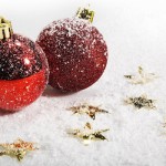 hd-kerst-wallpaper-met-sneeuw-gouden-sterretjes-en-twee-rode-kerstballen-achtergrond-foto